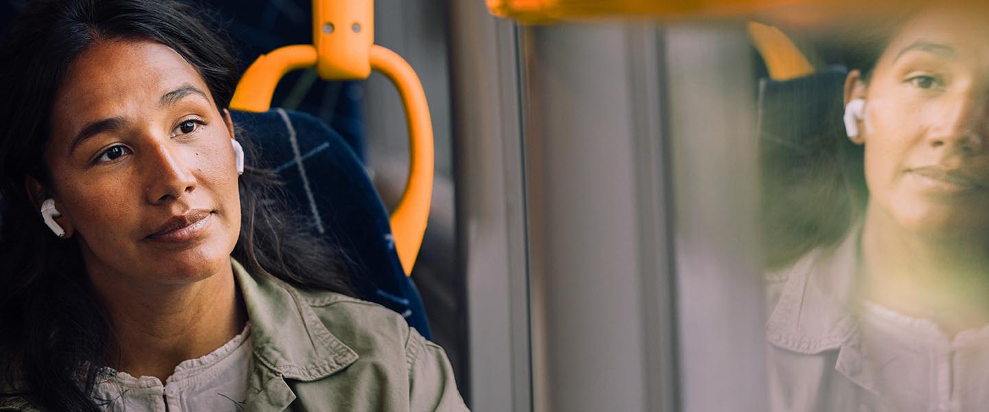 En kvinna med tjock mössa och jacka går från en buss.