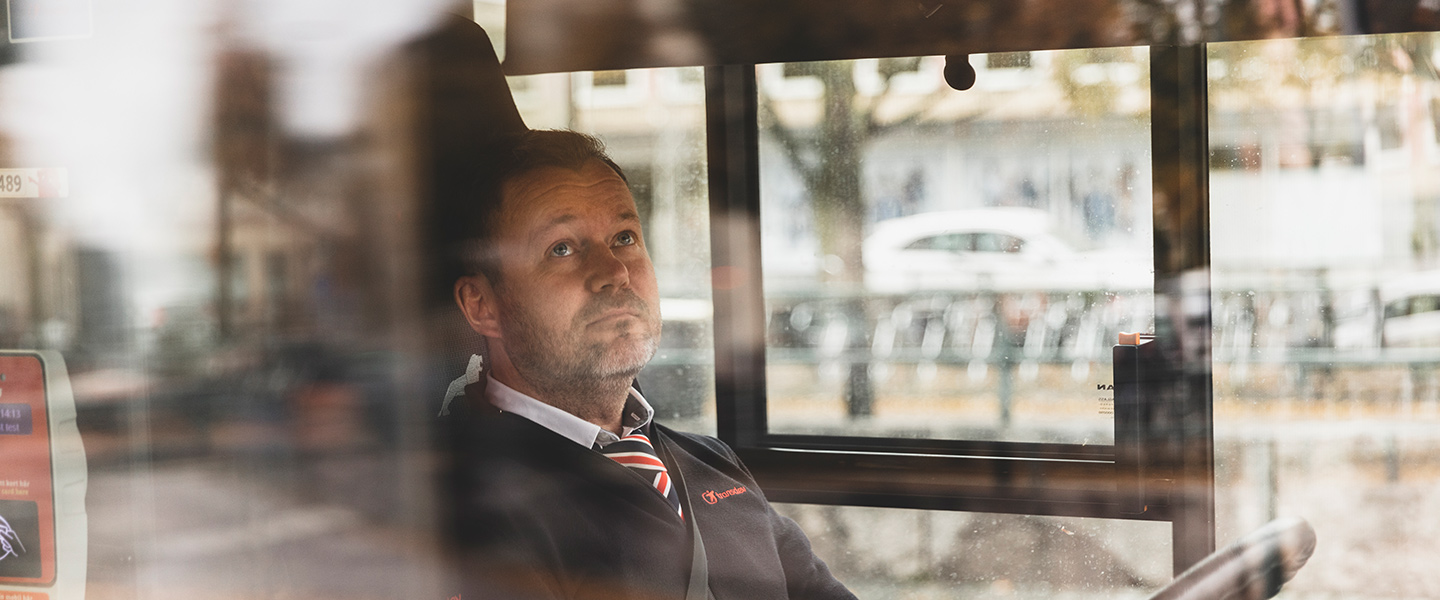 En bussförare syns bakom bussens fönster